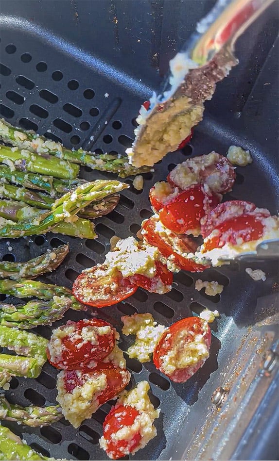 Seasoned grape tomatoes and asparagus in an air fryer