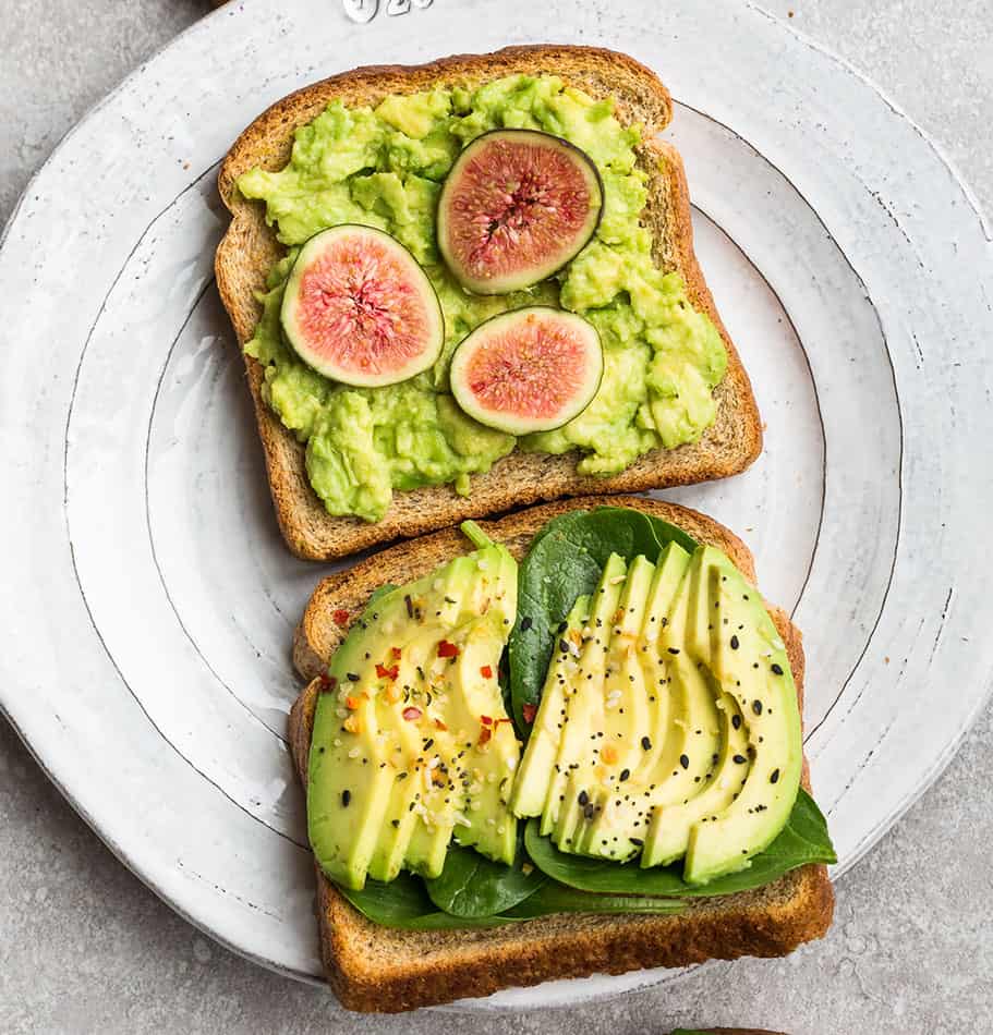 Top view of two slices of avocado toast on a white plate