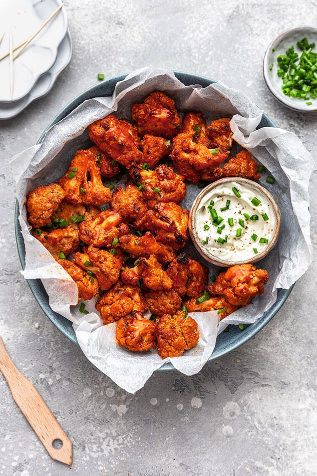 Overhead view of buffalo cauliflower wings with dipping sauce in serving dish