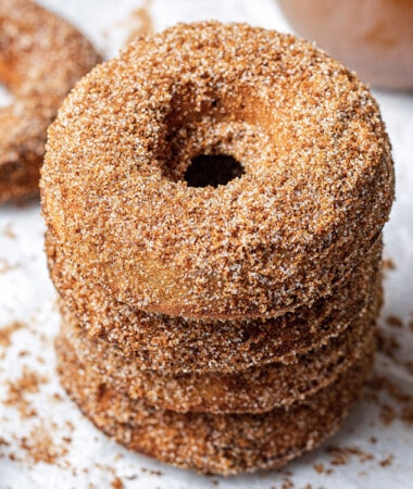 45 degree angle of four cinnamon donuts on a white background
