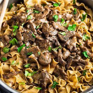 one pan beef stroganoff with mushrooms in a creamy gravy over cooked noodles