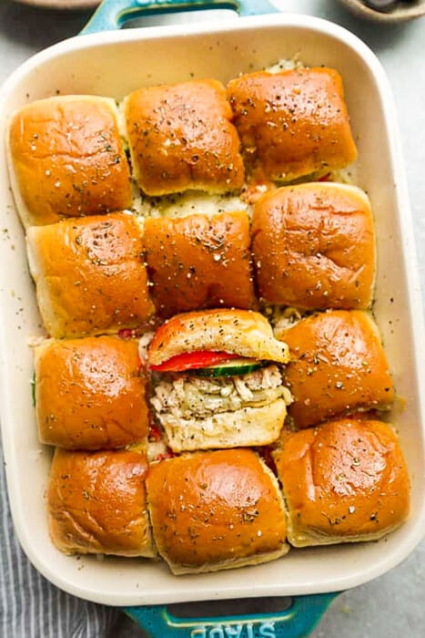 Top shot of 12 easy buffalo chicken sliders piled in a blue casserole pan