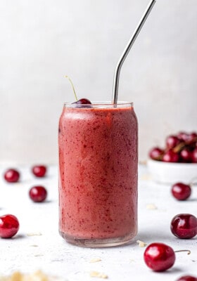 Side angle of one easy cherry smoothie in a glass with a straw