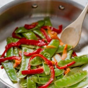 photo collage - snow peas, carrots and red bell peppers in a large skillet. Snow peas, red bell peppers and spinach in a large silver skillet.