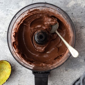 Creamy healthy chocolate pudding in a food processor bowl with a spoon