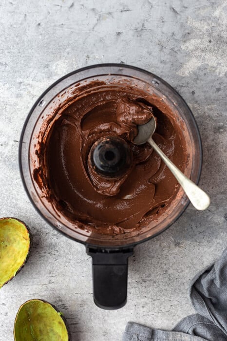 Creamy healthy chocolate pudding in a food processor bowl with a spoon