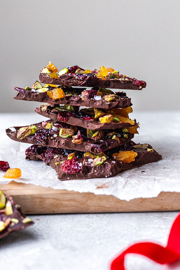 A stack of dark chocolate bark pieces with pistachios and dried fruit