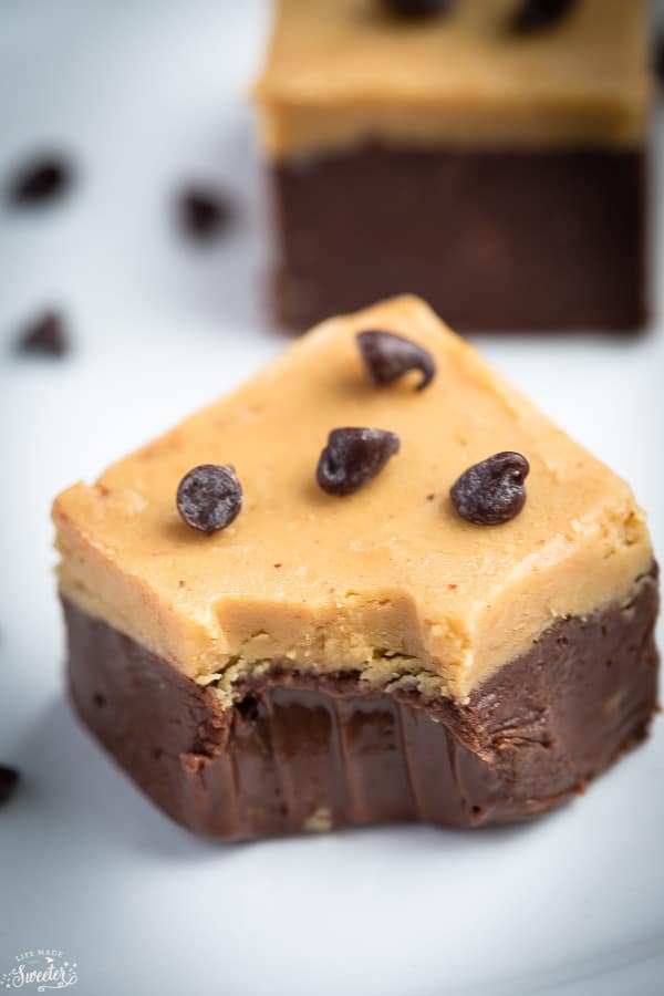Close-up of a square Chocolate Peanut Butter Layered Fudge with a bite removed