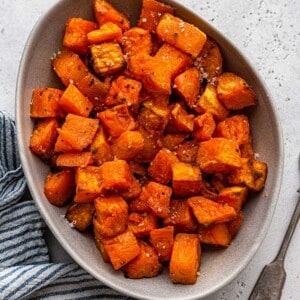 Cubed roasted sweet potatoes in a white oval serving platter