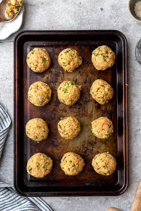 Top view of uncooked falafel balls on a baking pan