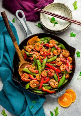 Garlic Shrimp Stir-Fry – an easy 30 minute one pan recipe perfect for busy weeknights. Tender and juicy shrimp sauteed with crunchy snap peas and red bell peppers coated in a delicious sweet and savory Asian-inspired sauce better than the local Chinese restaurant takeout. Best of all, paleo, gluten free and substitution suggestions for low carb.