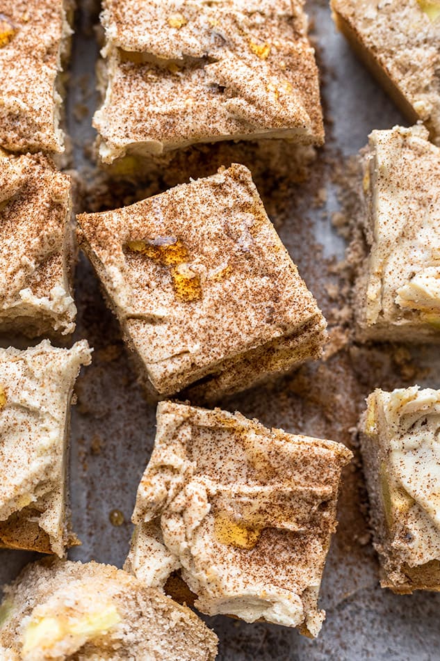 Overhead view of frosted apple cake squares topped with cinnamon
