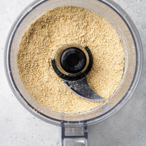 Top view of blended cashews in a food processor bowl