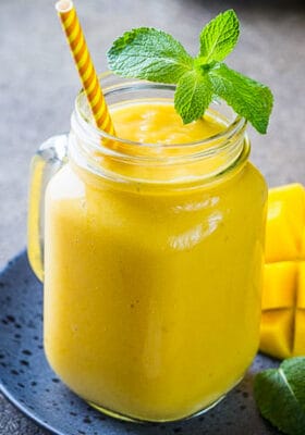Side view of one healthy mango smoothie in a mason jar