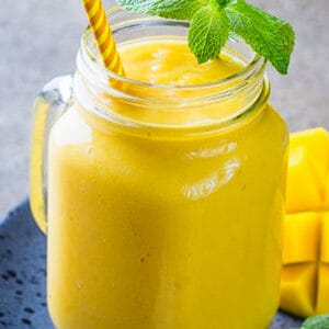 Side view of one healthy mango smoothie in a mason jar