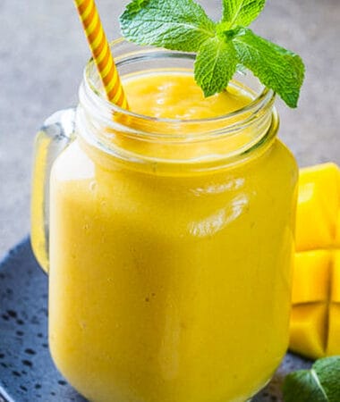 Side view of one healthy mango smoothie in a mason jar