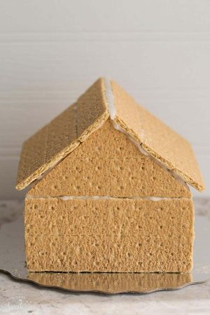 Easy No Bake Gingerbread House - An easy and simple way to make a "gingerbread" house using graham crackers and nuts. It's the perfect holiday activity for the kids and best of all, no baking required!