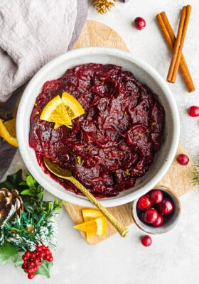 Top view of homemade cranberry sauce in a white bowl with a gold spoon