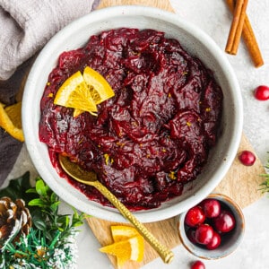 Top view of homemade cranberry sauce in a white bowl with a gold spoon