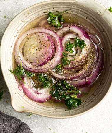 Overhead photo of easy pickled onions garnished with parsley.