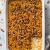 A baking dish full of pumpkin baked oatmeal with one slice missing from the bottom right corner
