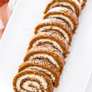 Overhead view of slices of pumpkin roll on a serving platter with powdered sugar