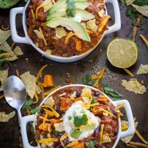 Two bowls of Easy Slow Cooker Chili topped with cheese, sour cream and avocado