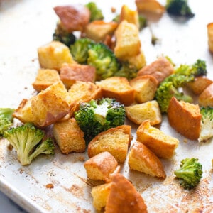 Roasted broccoli florets and crispy homemade croutons on a baking sheet