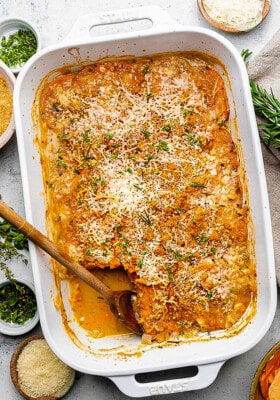 Overhead view of scalloped sweet potatoes in a baking dish with a serving removed