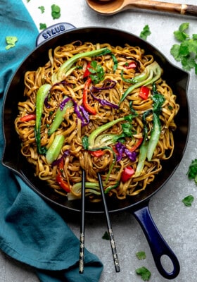 Top view of vegetable lo mein in a blue skillet with chopsticks