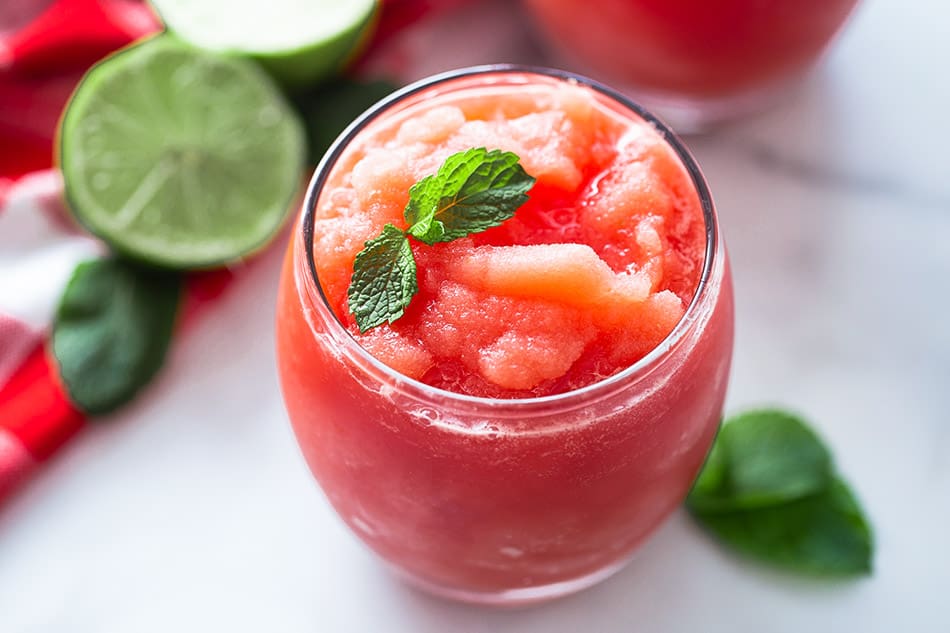 Landscape shot of a watermelon slushie in a glass cup with mint