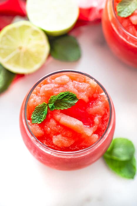A Watermelon Slushie in a Drinking Glass with Two Mint Leaves on Top