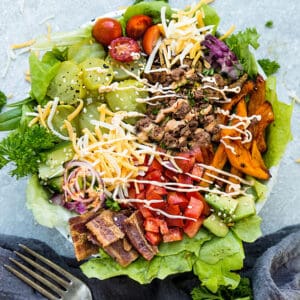 Top view of keto burger in a bowl in a white bowl with pumpkin fries on a grey background