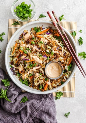 Top view of egg roll in a bowl in a white bowl with chopsticks