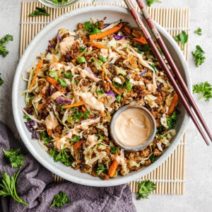 Top view of egg roll in a bowl in a white bowl with chopsticks