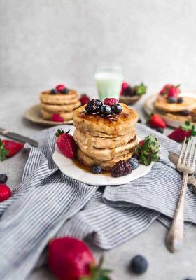 Eggless pancakes on a plate with strawberries, raspberries, blackberries and blueberries