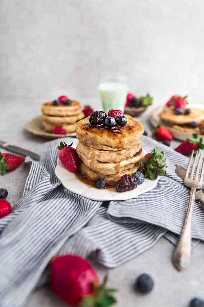 Eggless pancakes on a plate with strawberries, raspberries, blackberries and blueberries