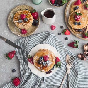 Eggless pancakes on a plate with strawberries, raspberries, blackberries and blueberries