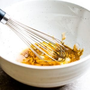 A white bowl with a whisk to make protein bites