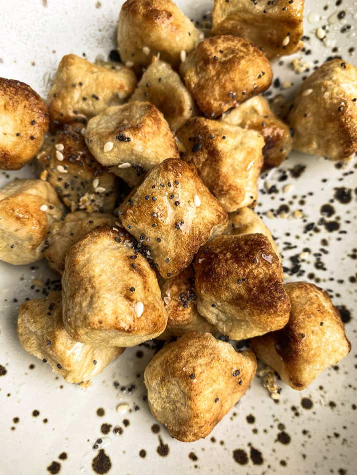 A Close-Up View of Everything Bagel Cauliflower Gnocchi in a White and Black Speckled Bowl