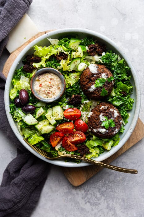 Falafel Salad in a white bowl with a gold fork