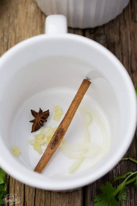 Top view of a cinnamon stick, ginger and star anise in a mug