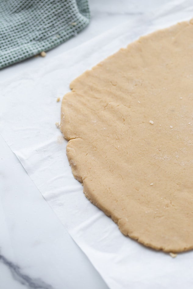 A rectangle of rolled out dough on top of parchment paper
