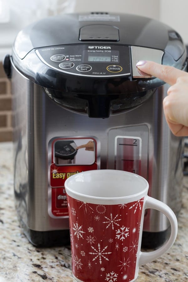 A mug in front of a water boiler appliance