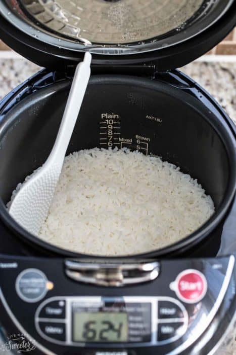 Cooked rice in a rice cooker with a spoon
