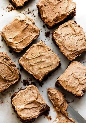 Paleo Brownies with dairy free chocolate frosting next to a silver butter knife with chocolate frosting.