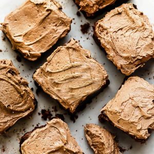 Paleo Brownies with dairy free chocolate frosting next to a silver butter knife with chocolate frosting.