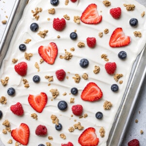 Overhead view of yogurt topped with fresh mixed berries and granola