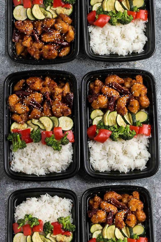 meal prep containers filled with General Tso's Chicken, white rice and steamed vegetables