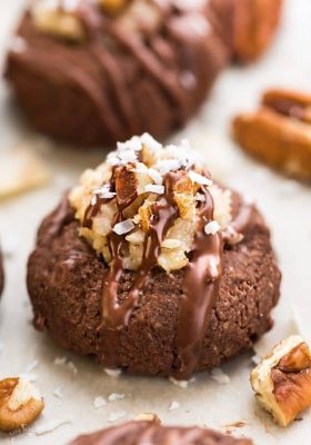 German Chocolate Thumbprint Cookies are all of the things you love about German Chocolate Cake in a cute little thumbprint cookie! A rich, chocolate shortbread with a coconut pecan frosting and drizzled in chocolate!
